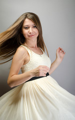 Young cute woman dancing in dress