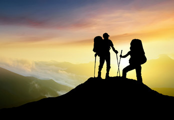 Silhouettes of team on mountain peak. Sport and active life concept..