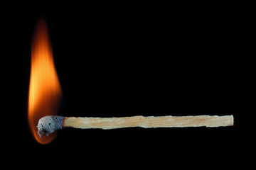 Burning match stick isolated on black