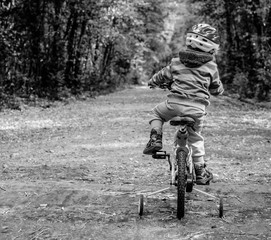 child riding a bicycle in the woods