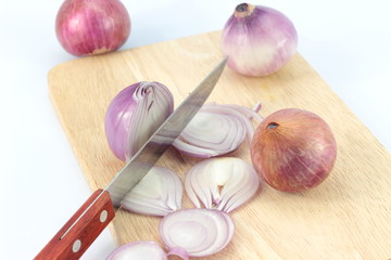 Turned red onions on a wooden cutting board
