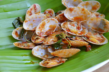 stir fried clams with roasted chili paste on fresh banana leaf