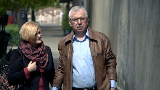 Mature couple talking during walk in city, super slow motion 240fps
