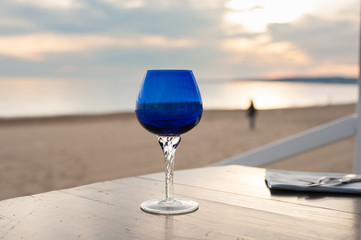 Blue glass closeup on romantic sunset beach