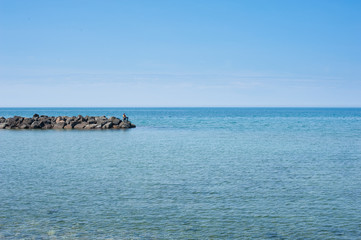 Fisherman alone in large blue sea landscape
