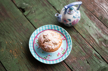 Coffee cake muffin served in a beautiful plate next to a china milk jug