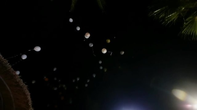 balloons rising into the night sky 