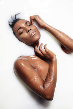 pretty black woman in a milky bath