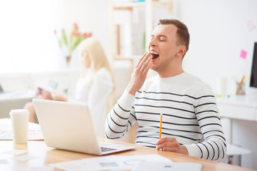 Obraz premium Pleasant guy sitting at the table in office 