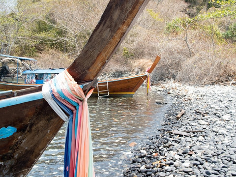 Prow of local traditional long tail boat tied with fabric three colors.