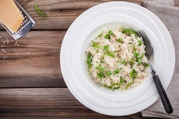 Homemade risotto with chicken, green peas, arugula and parmesan