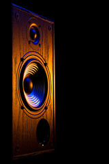 audio speaker illuminated in blue and orange on a black background isolated