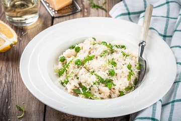 Homemade risotto with chicken, green peas, arugula and parmesan