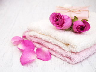 Obraz na płótnie Canvas Bath towels and soap with pink roses