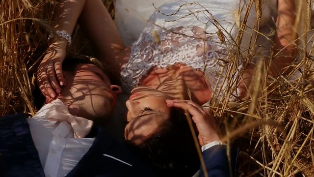 bride and groom lying in the field 
