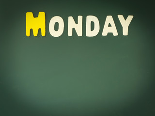 Wooden Monday on Green Board. Wood Monday word on blackboard with copy space.