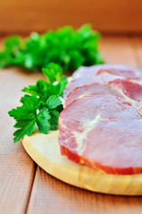 Jerky, garnished with sprigs of parsley on a cutting board on a wooden background close up