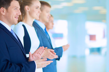 Smiling business people applauding a good presentation in the office