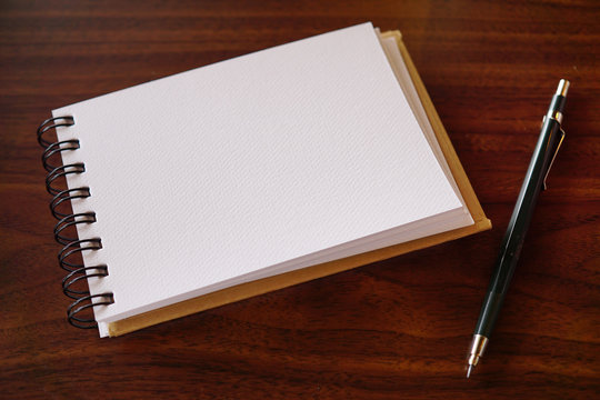 Open a blank white notebook. with pencil