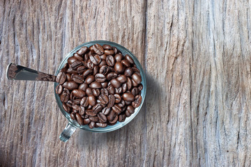 Coffee beans in coffee cup wood background