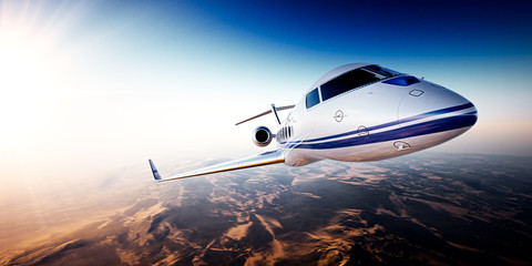 Fototapeta premium Realistic photo of white generic design private Jet flying over the mountains. Empty blue sky with sun at background.Business Travel by modern Luxury Plane.Horizontal.Closeup image. 3d rendering