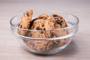 chocolate cookies in glass bowl on wooden background