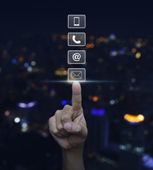 Hand pressing telephone, mobile phone, at and email buttons over © grapestock