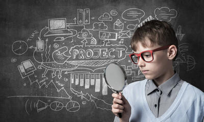 Curious school boy with magnifier