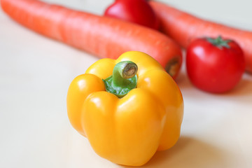 yellow bell pepper on blurred background of vegetables