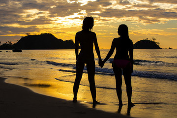 Silhouette of two girls at sunset on the beach