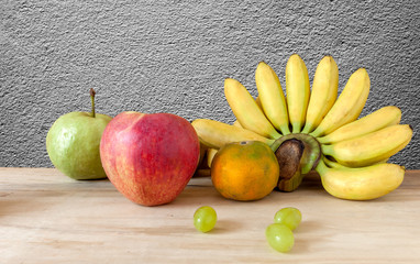 Fresh fruit apple grapes banana and grange with background