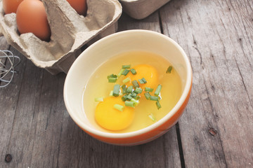 Eggs in box and bowl with whisk