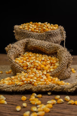 Dried corn in sackbag on wooden table