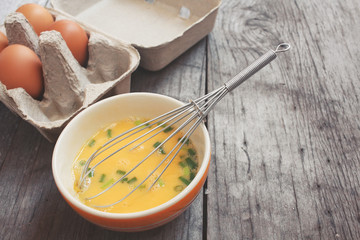 Eggs in box and bowl with whisk