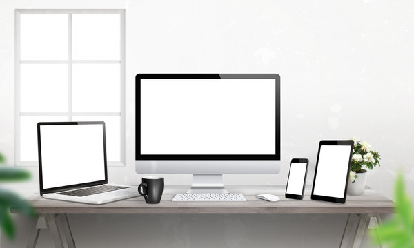 Responsive devices on desk with isolated screen for mockup. Computer display, laptop, tablet and smart phone. 