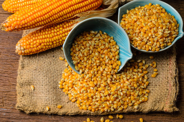 Dried corn in blue ceramic bowl on wooden table