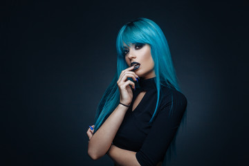 Portrait of a young woman with a cyan color hair