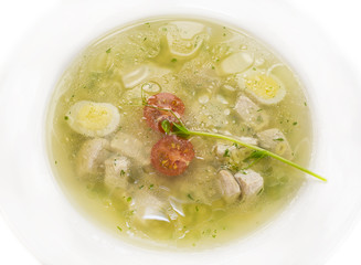 broth with pasta greens and quail egg in a white plate