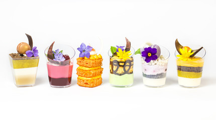 mini canapes in plastic cups decorated with edible flowers