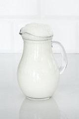 Jug of butttermilk on white table