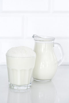 Glass of butttermilk on white table