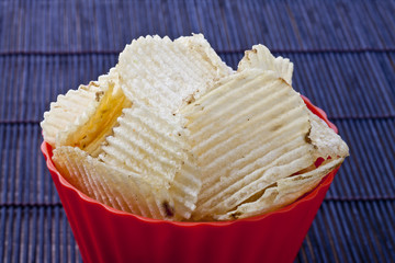 fried potato chips in red plastic bowl