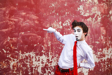 Mime points a finger at the center against a background of a red