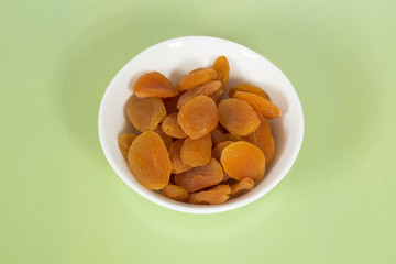 Dried apricots on a green background
