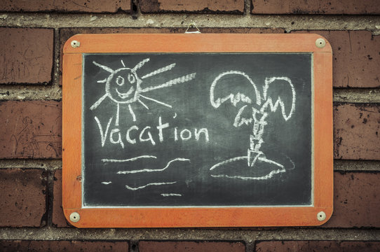Tafel an einer Ziegelwand mit Text / Tafel an einer Ziegelwand mit Text Vacation.