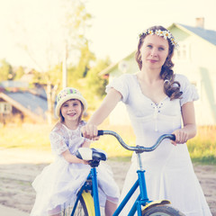 Beautiful mother and daughter traveling on a bicycle.