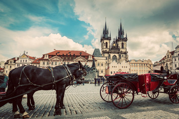 Fototapeta na wymiar Old Town of Prague, Czech Republic. Horse carriage for tourists. Tyn Church, vintage