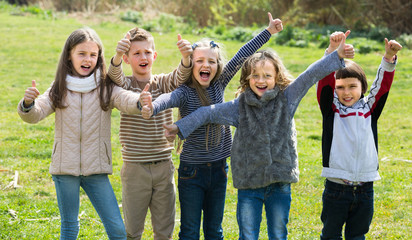 kids showing thumbs up outdoors