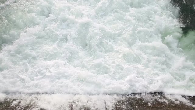 Agua saliendo a borbotones en el punto de evacuacion de una presa o dique de embalse 

