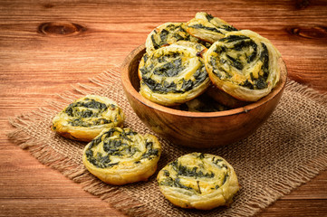 Fototapeta premium Spinach and feta puffs on wooden background.